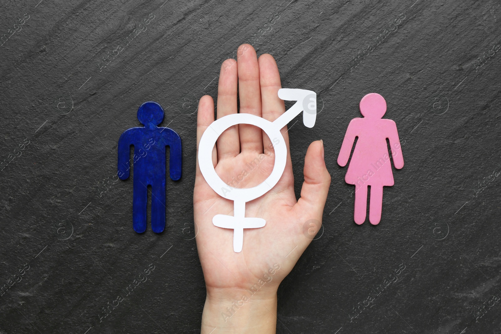 Photo of Gender equality concept. Woman with female and male figures at grey textured table, top view