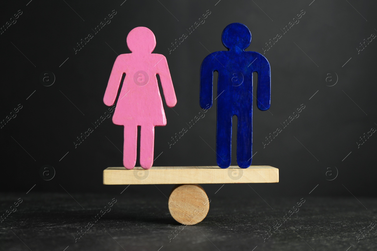 Photo of Gender equality concept. Male and female figures on scales against grey background