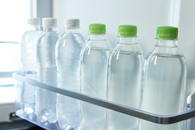 Photo of Many bottles of water in refrigerator, closeup