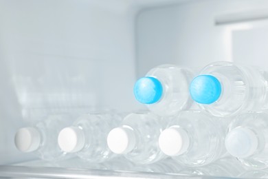 Photo of Many bottles of water in refrigerator, closeup