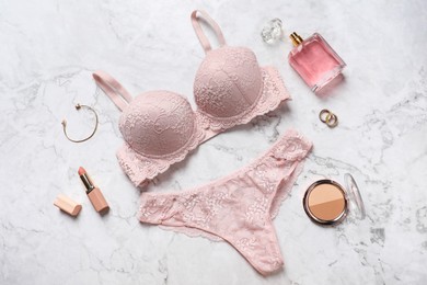 Photo of Beautiful lace lingerie set and accessories on light marble background, flat lay