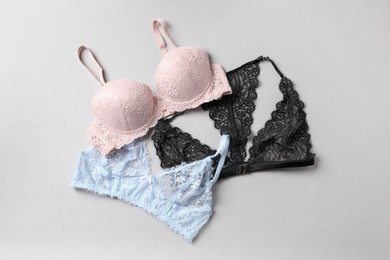 Photo of Different lace bras on grey background, top view