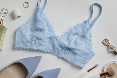 Photo of Beautiful lace bra and accessories on white background, flat lay