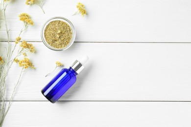 Photo of Bottle of tincture and helichrysum flowers on white wooden table, flat lay. Space for text