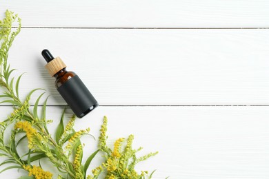 Photo of Bottle of tincture and goldenrods flowers on white wooden table, flat lay. Space for text