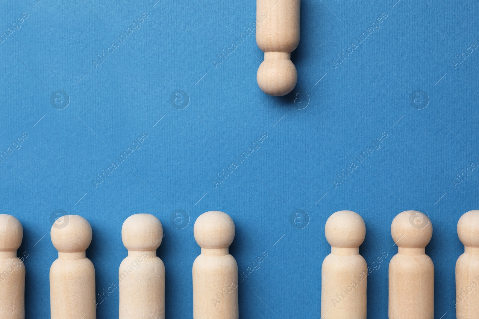 Photo of Loneliness concept. Human figure distant from others on blue background, top view