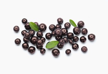 Photo of Ripe acai berries and leaves on white background, flat lay