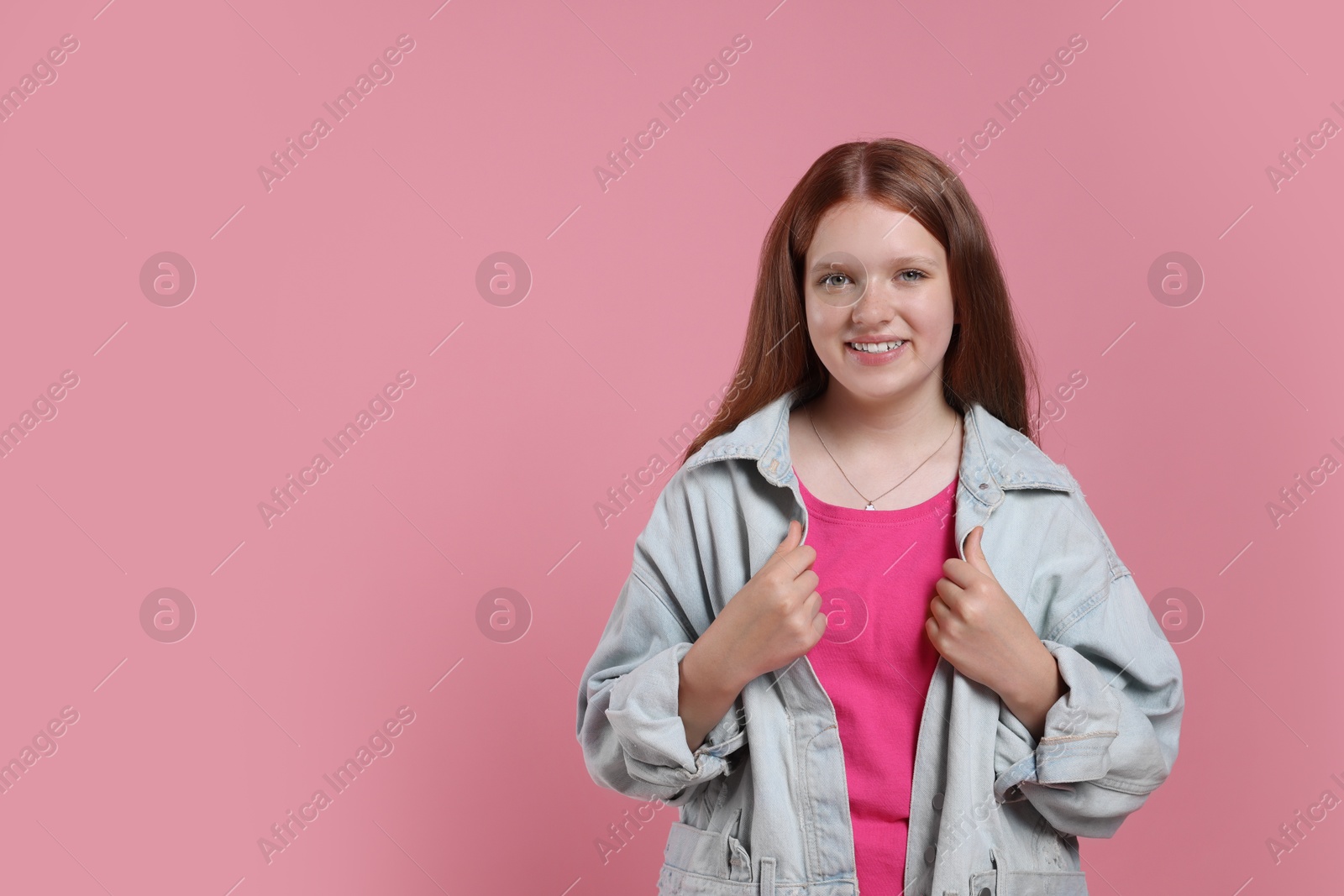 Photo of Portrait of teenage girl on pink background, space for text