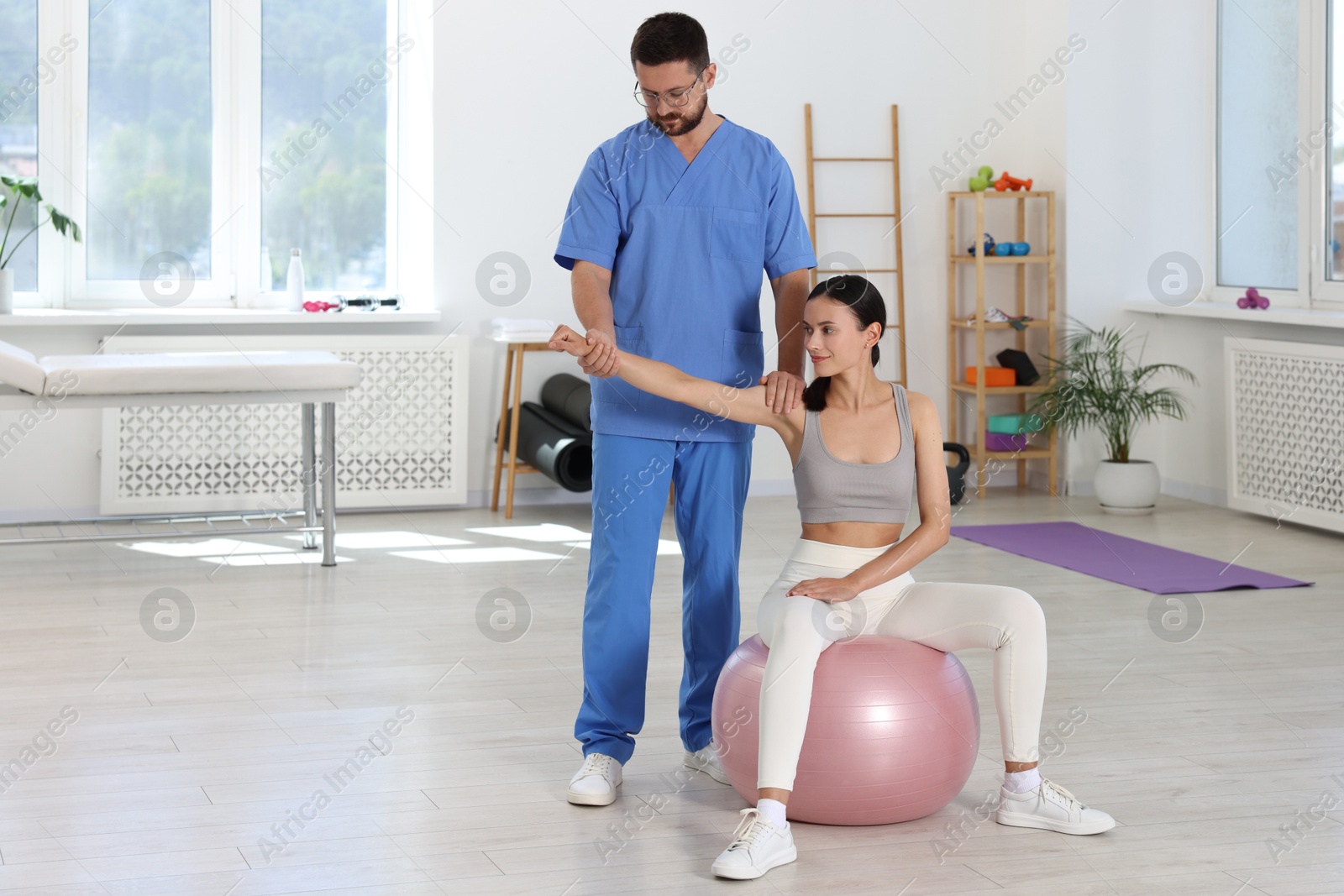 Photo of Physiotherapist working with patient in rehabilitation center