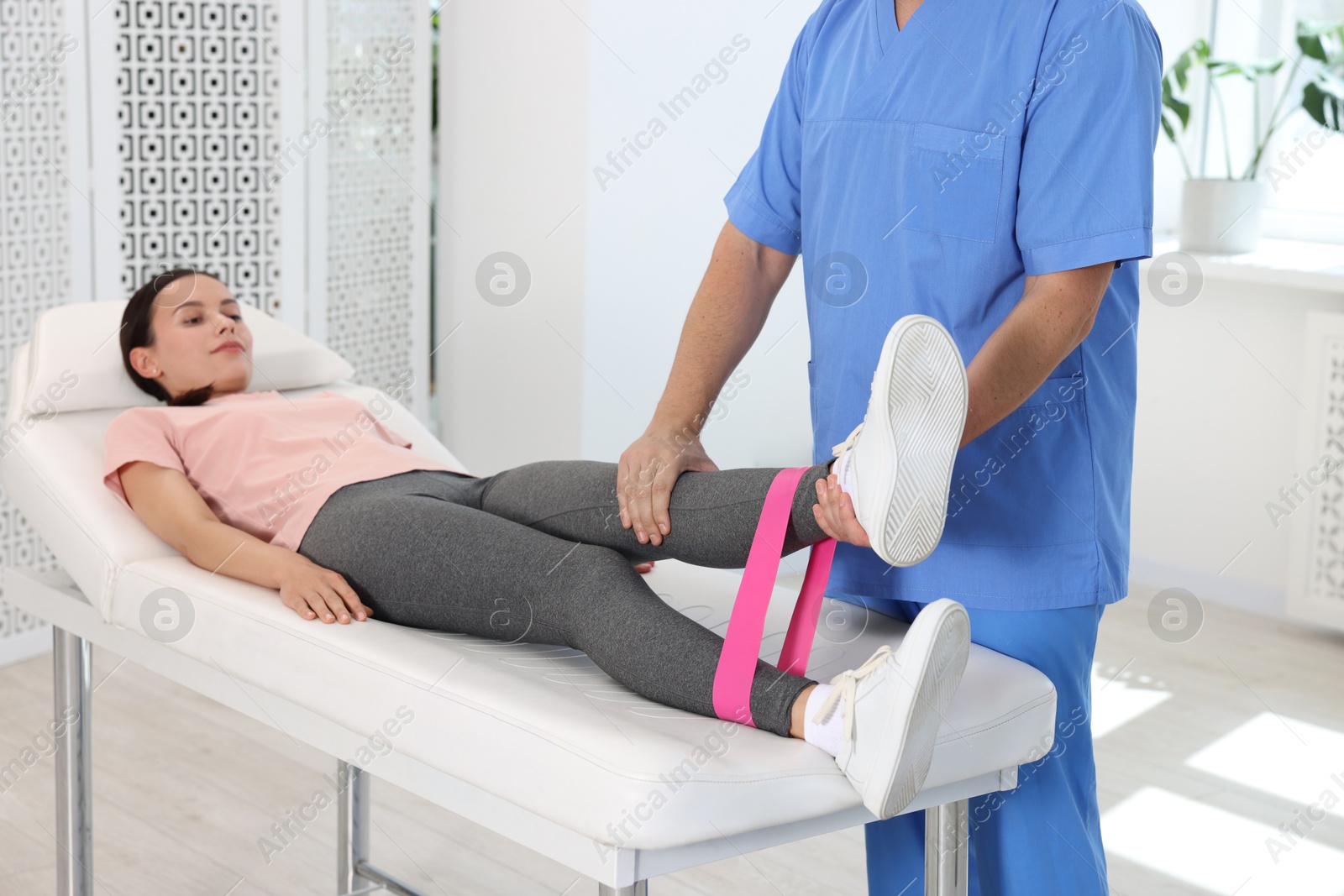 Photo of Physiotherapist working with patient in rehabilitation center