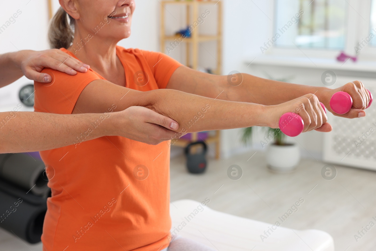 Photo of Senior patient exercising under physiotherapist supervision in rehabilitation center, closeup