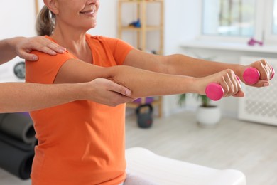 Senior patient exercising under physiotherapist supervision in rehabilitation center, closeup