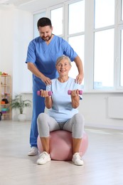 Senior patient exercising under physiotherapist supervision in rehabilitation center