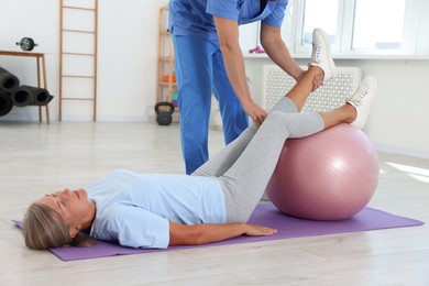 Physiotherapist working with senior patient in rehabilitation center