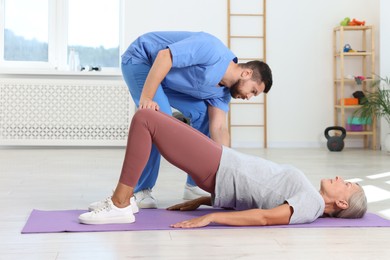 Physiotherapist working with senior patient in rehabilitation center