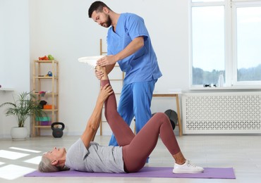 Physiotherapist working with senior patient in rehabilitation center