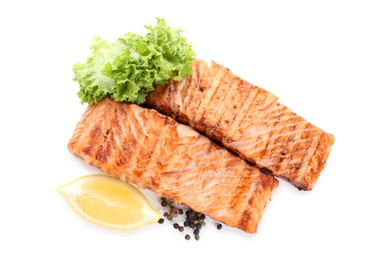 Photo of Delicious grilled salmon fillets with peppercorns, lemon and lettuce isolated on white, top view