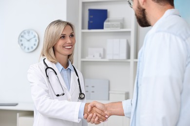 Doctor shaking hands with patient in hospital