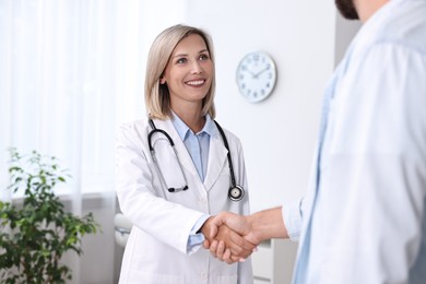 Doctor shaking hands with patient in hospital