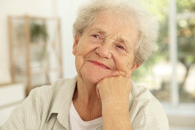 Portrait of beautiful senior woman against blurred background