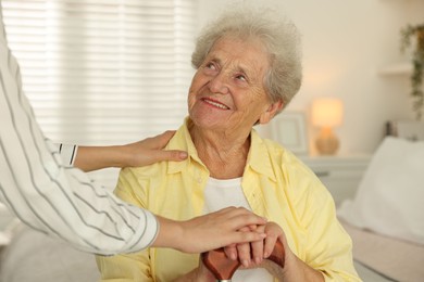 Photo of Senior woman with walking cane and her granddaughter at home