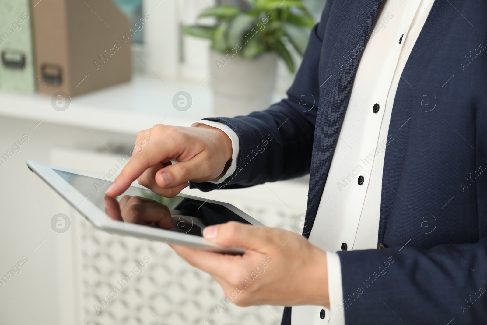 Photo of Businesswoman using tablet indoors, closeup. Modern technology