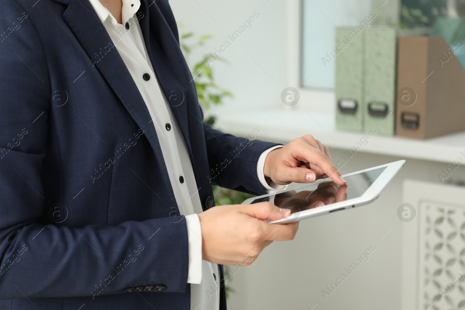 Photo of Businesswoman using tablet indoors, closeup. Modern technology