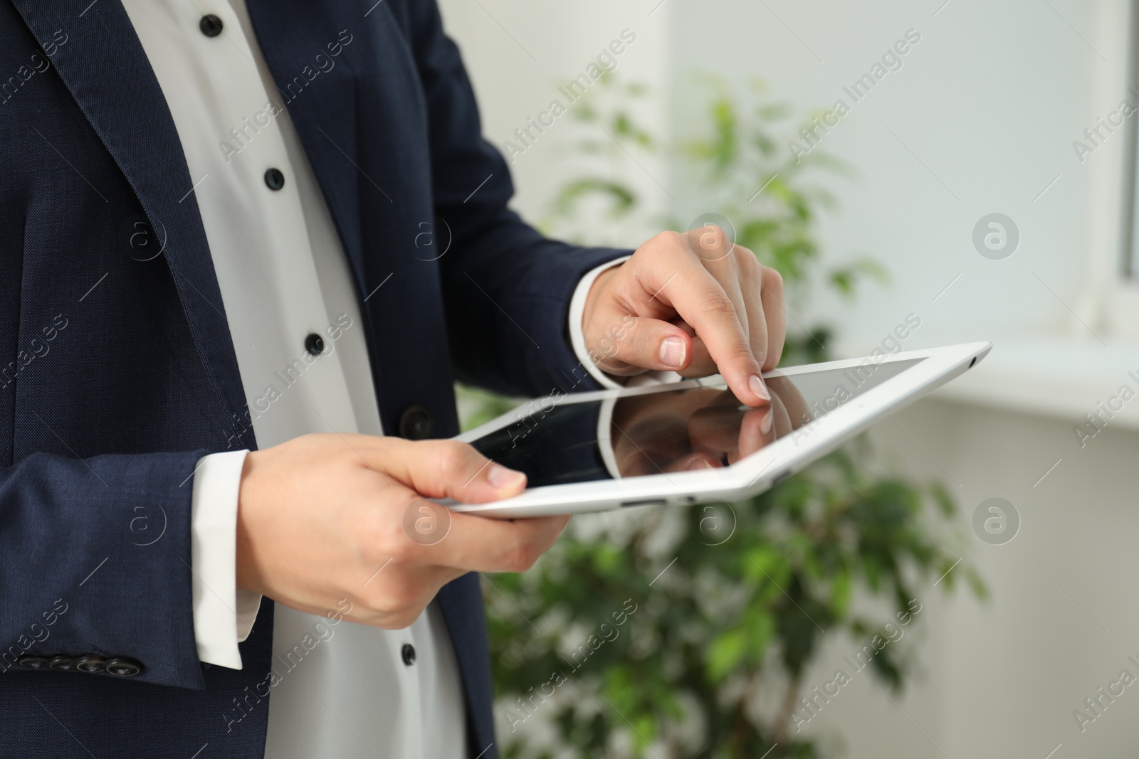 Photo of Businesswoman using tablet indoors, closeup. Modern technology