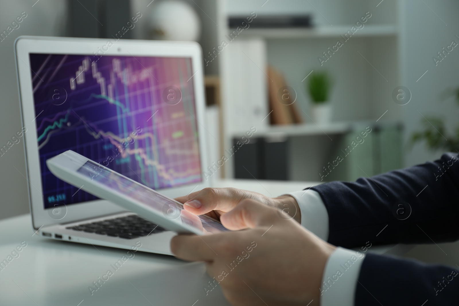 Photo of Businesswoman using tablet at white table indoors, closeup. Modern technology