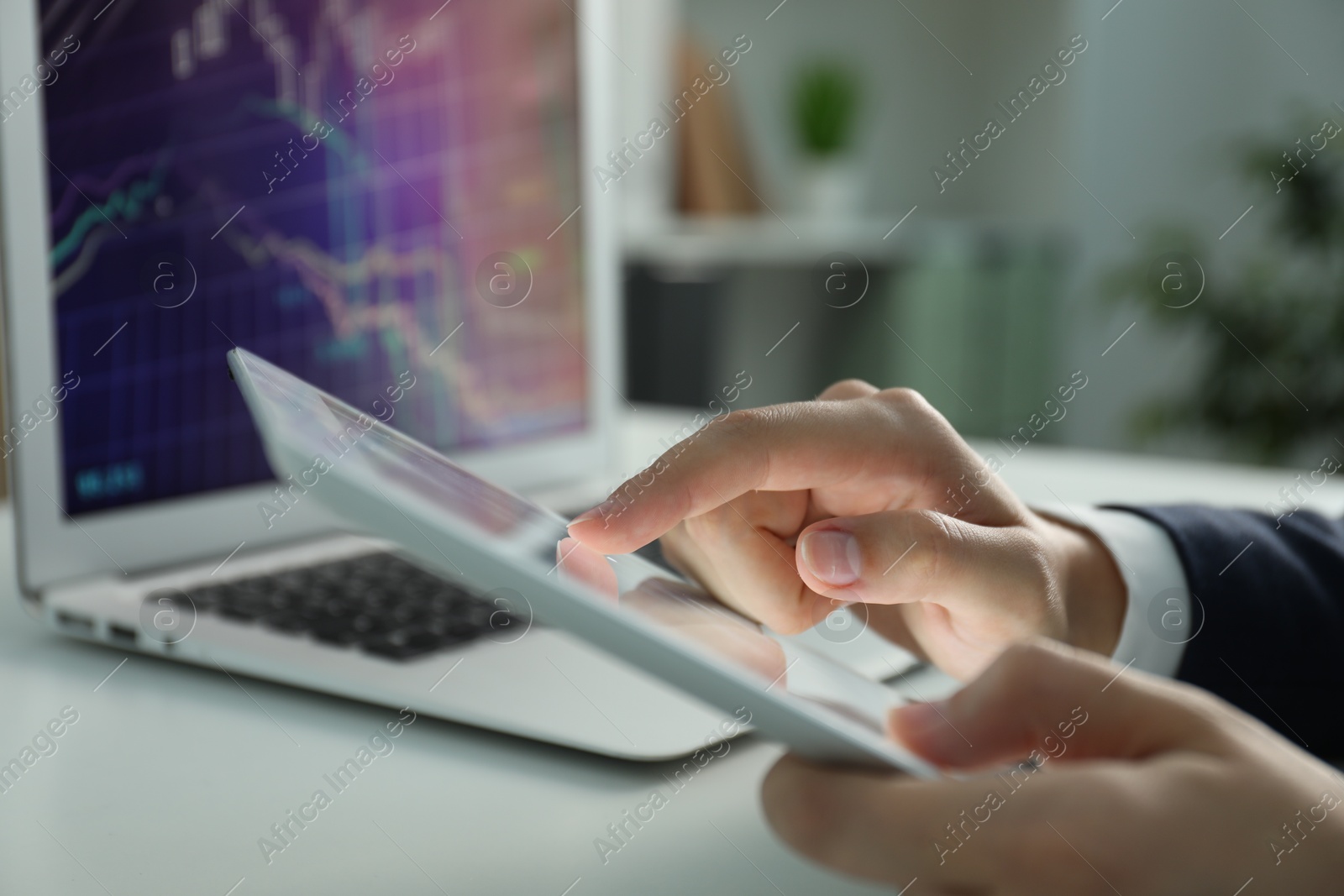 Photo of Businesswoman using tablet at white table indoors, closeup. Modern technology