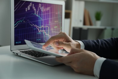 Photo of Businesswoman using tablet at white table indoors, closeup. Modern technology