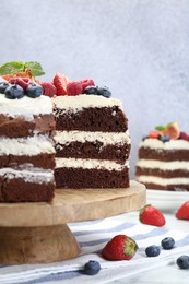 Delicious chocolate sponge cake with berries served on white table