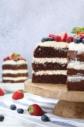 Delicious chocolate sponge cake with berries served on white table