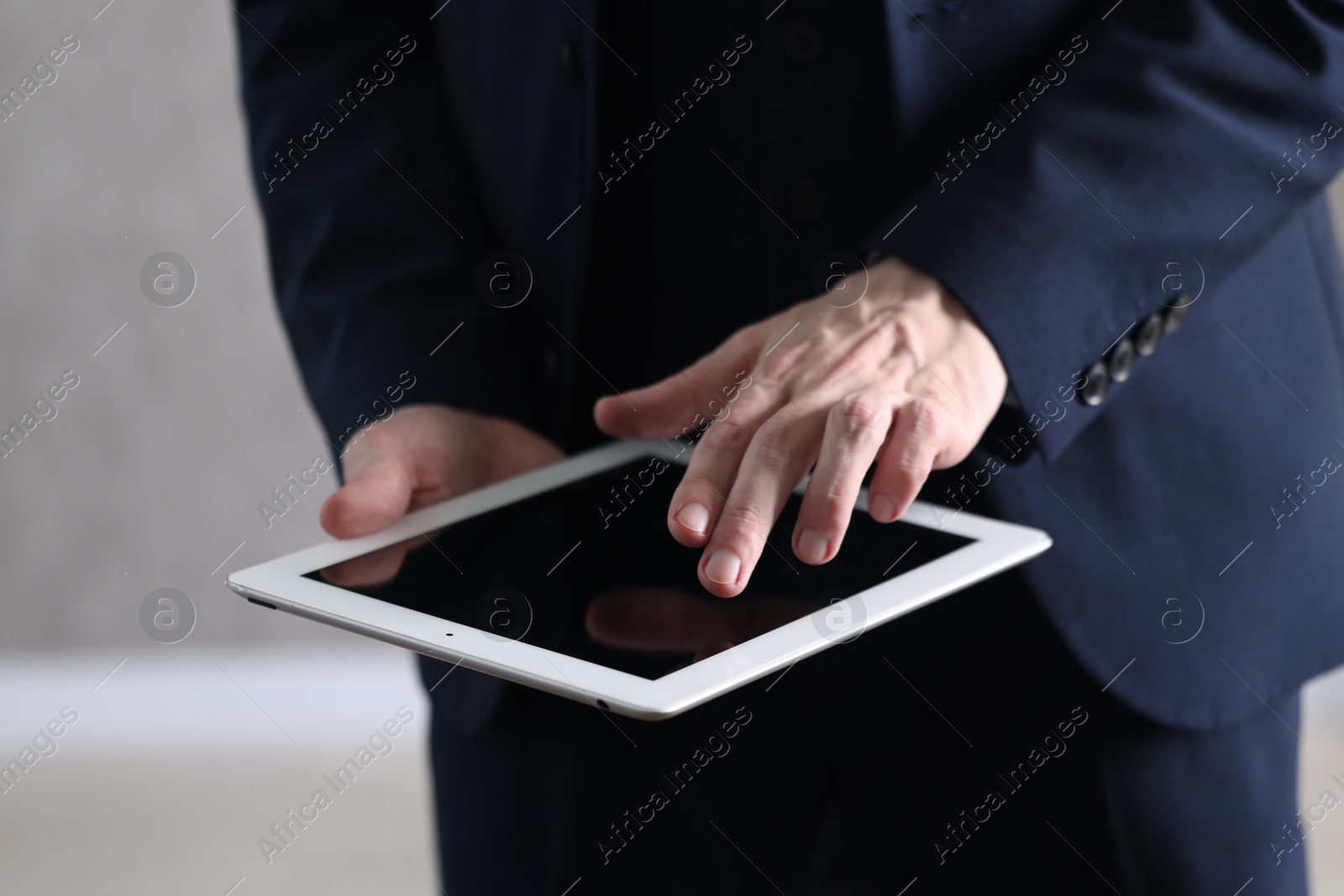 Photo of Businessman using tablet indoors, closeup. Modern technology