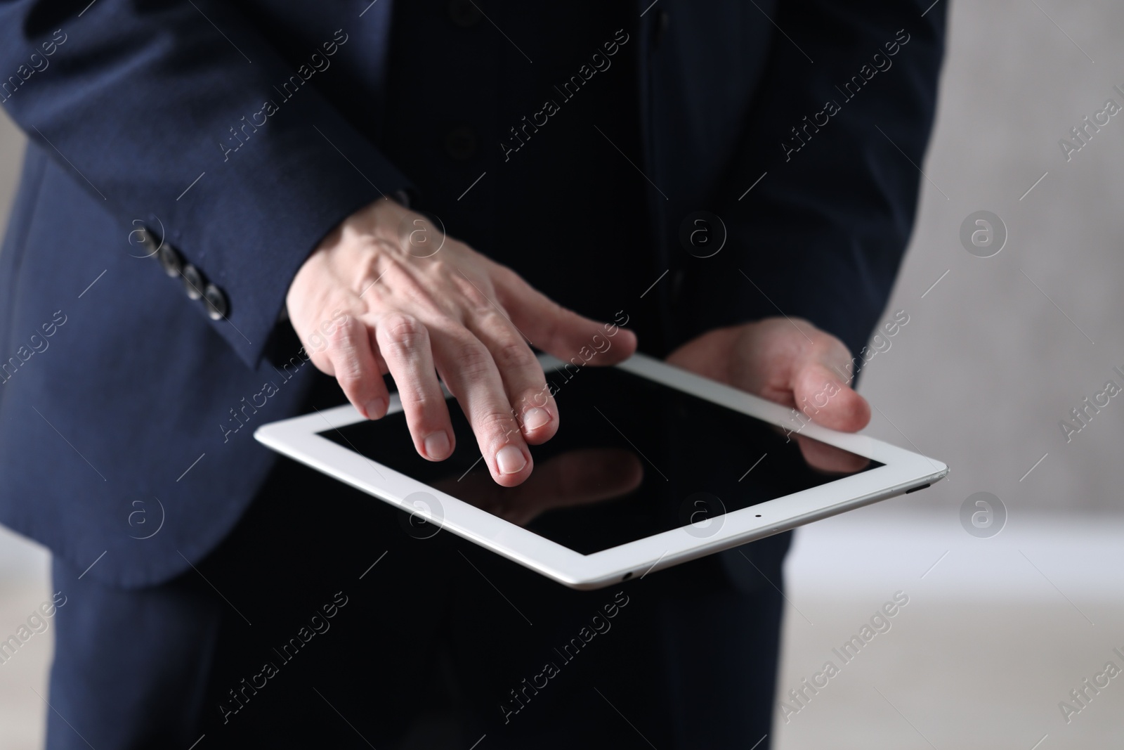 Photo of Businessman using tablet indoors, closeup. Modern technology