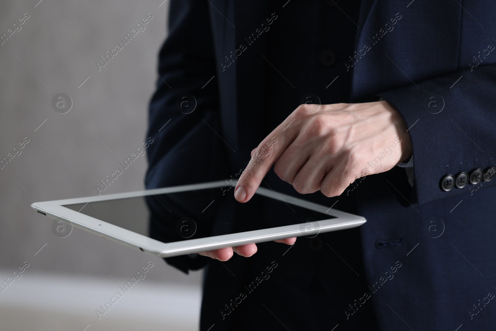 Photo of Businessman using tablet indoors, closeup. Modern technology