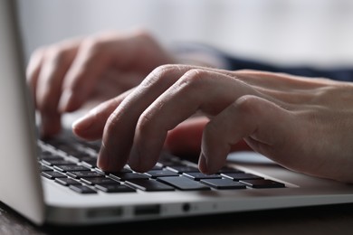 Photo of Businessman using laptop indoors, closeup. Modern technology