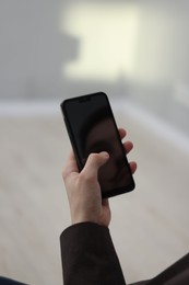 Photo of Businessman using smartphone on blurred background, closeup. Modern technology