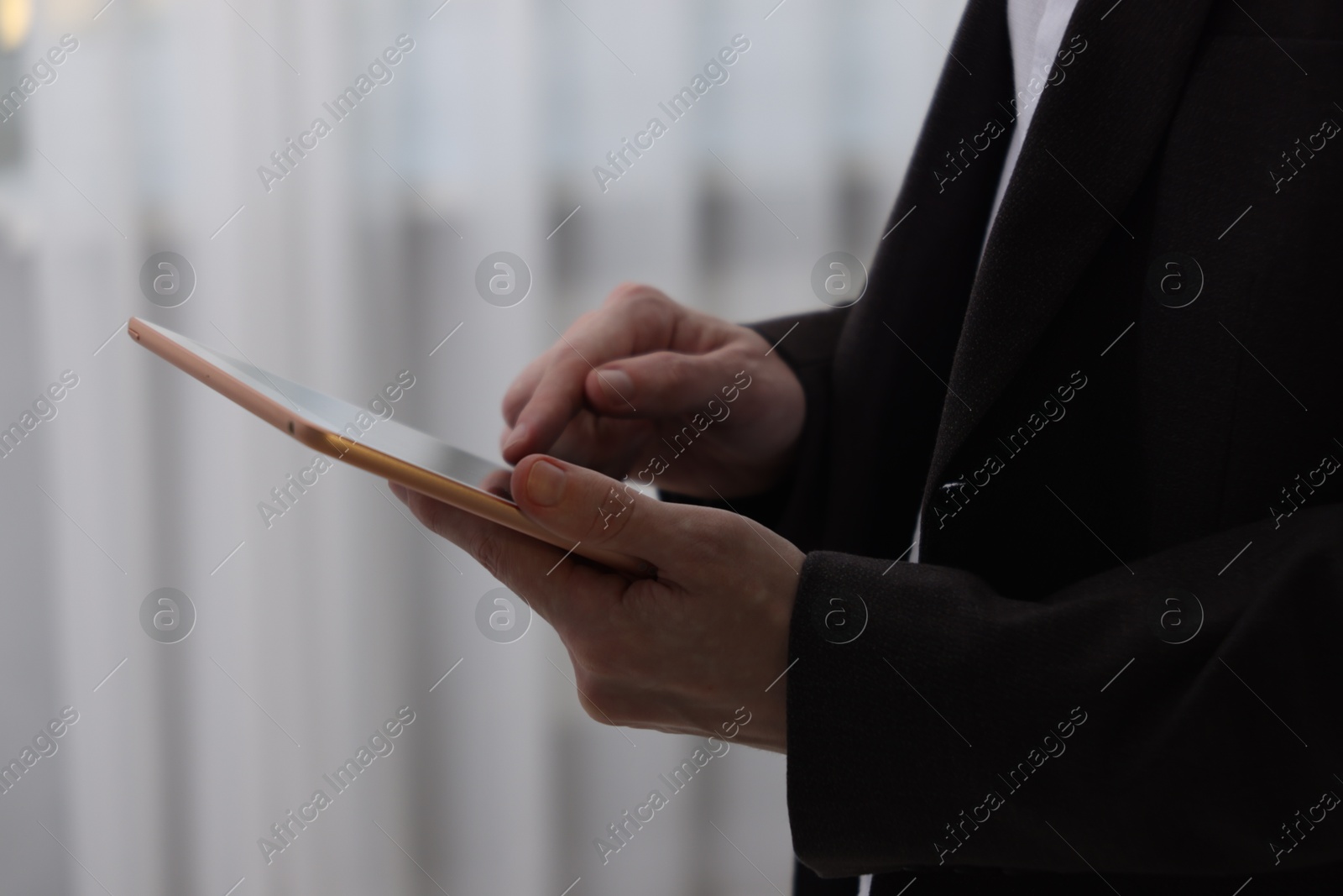 Photo of Businessman using tablet indoors, closeup. Modern technology