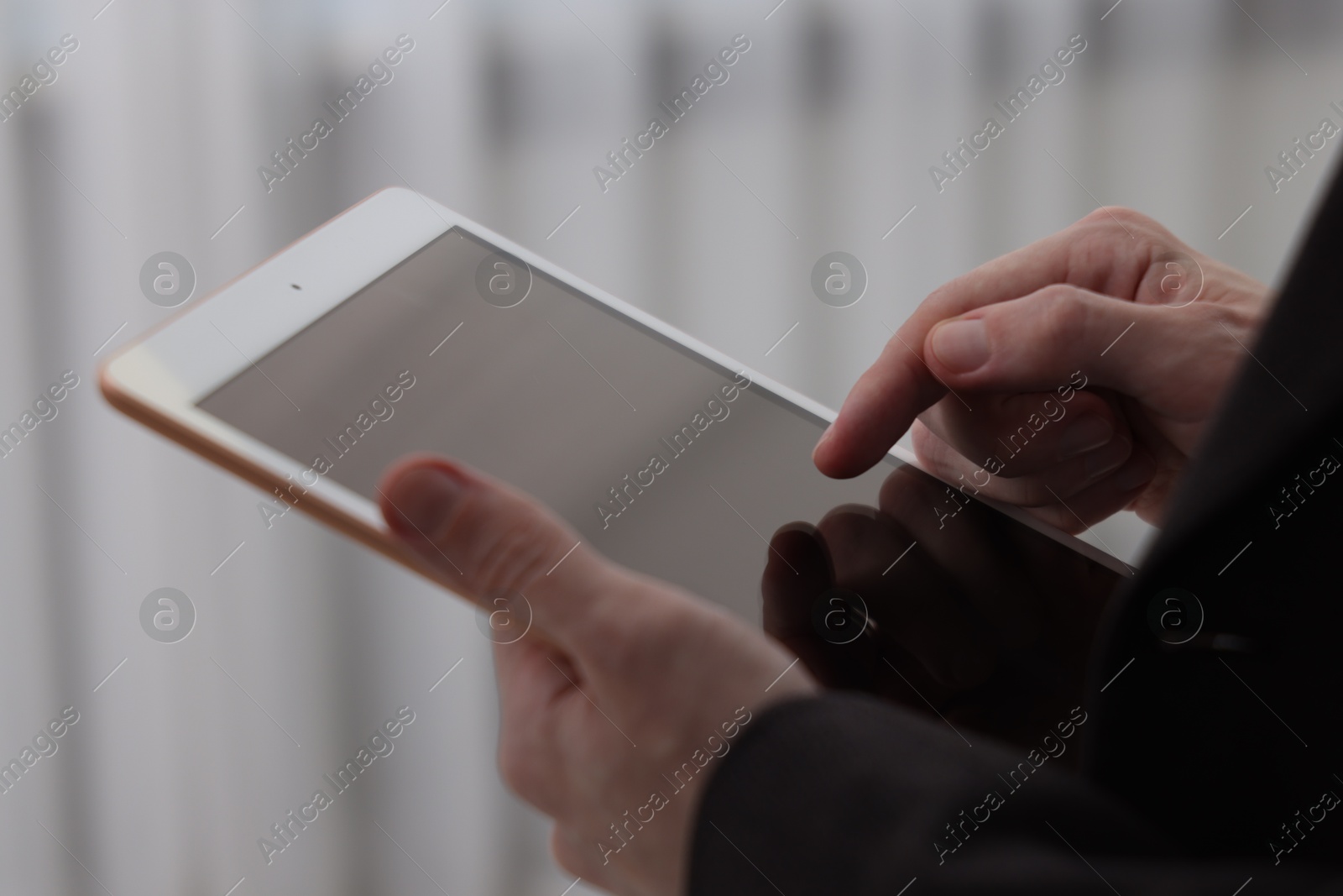 Photo of Businessman using tablet indoors, closeup. Modern technology