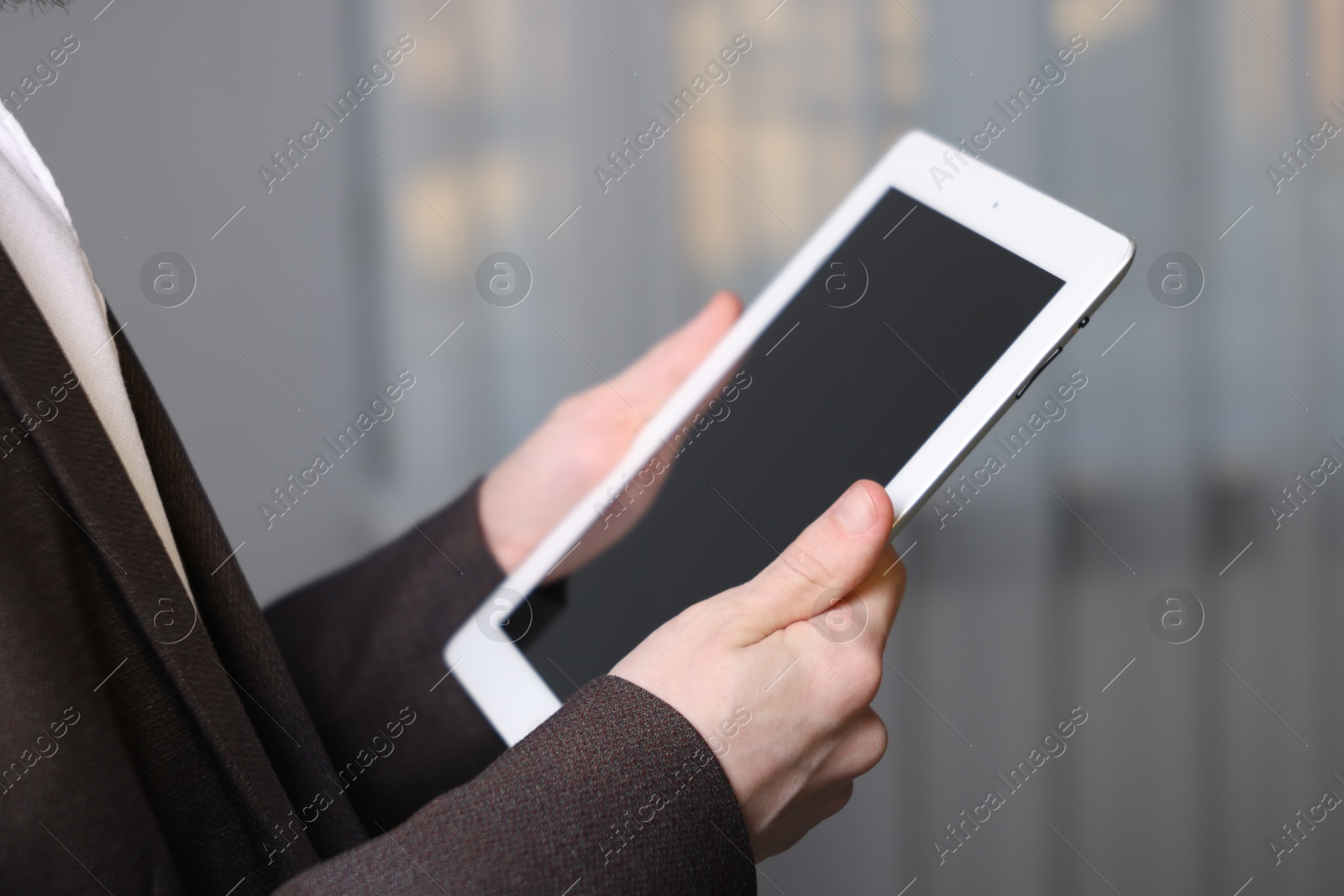 Photo of Businessman using tablet indoors, closeup. Modern technology