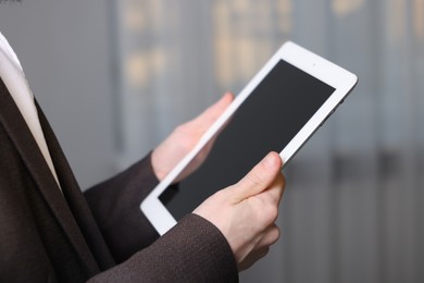 Photo of Businessman using tablet indoors, closeup. Modern technology