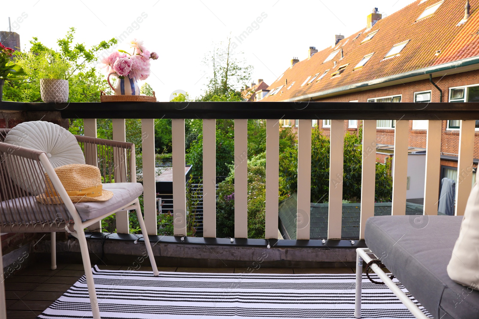 Photo of Different plants on railings and chair at cozy balcony outdoors