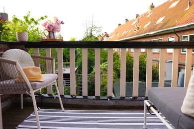 Different plants on railings and chair at cozy balcony outdoors