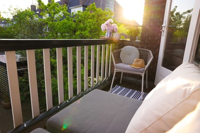 Different plants on railings and chair at cozy balcony outdoors