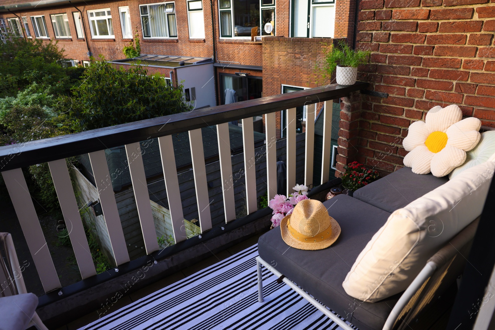 Photo of Soft chairs, hat and plants at cozy balcony