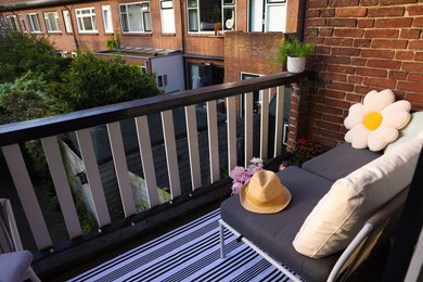 Soft chairs, hat and plants at cozy balcony