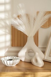 Beautiful decorative plants, vases and ceramic bowl on wooden table indoors