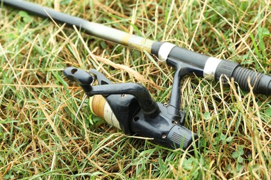 One fishing rod on green grass, closeup