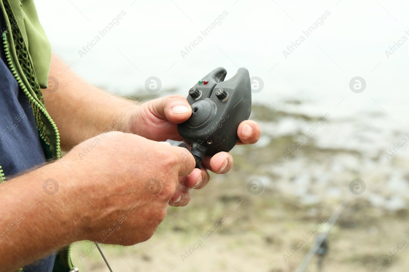 Photo of Senior fisherman holding fishing equipment outdoors, closeup